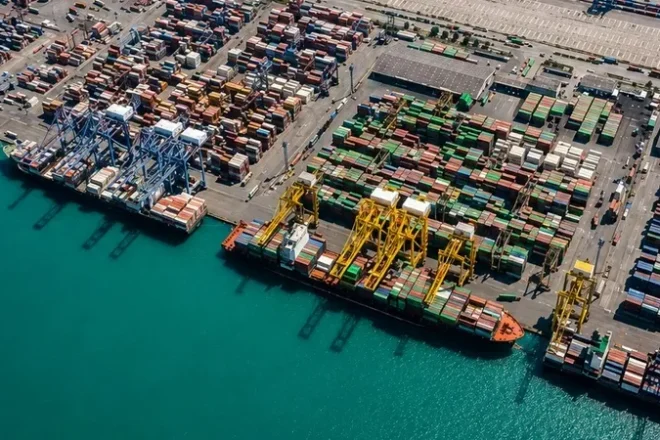 Container ship transporting cargo across international waters as part of a global sourcing and supply chain network.