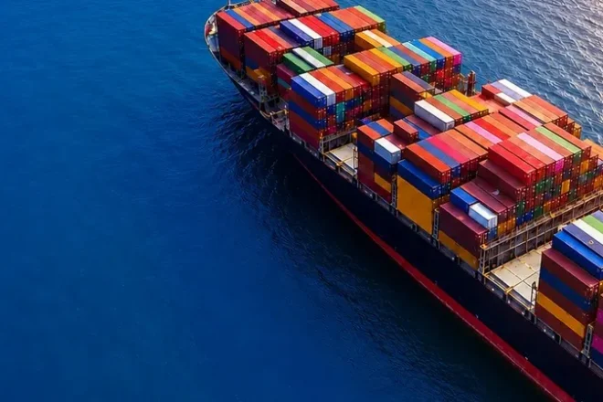 Container ship transporting cargo across international waters as part of a global sourcing and supply chain network.