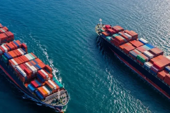 Container ship transporting cargo across international waters as part of a global sourcing and supply chain network.